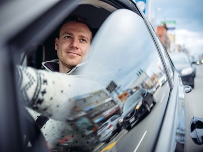 Man looking out car window while driving