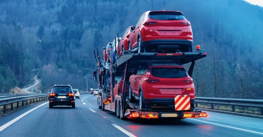 small car driving past a large truck