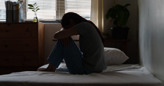 Depressed woman in her home after a non-physical workplace injury.