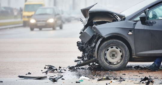 close up of a black car with a smashed front end