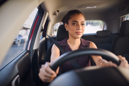 Woman driver feeling hesitant while holding the steering wheel